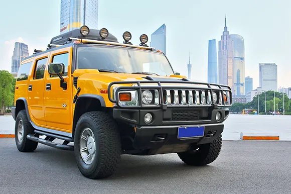 A yellow Hummer H2 in front of the city of Guangzhou.