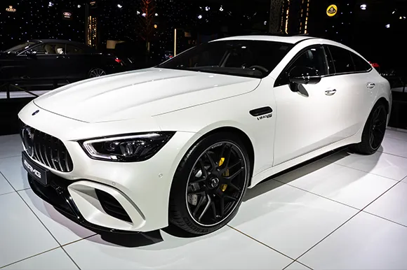 A white Mercedes-AMG GT 63 S sports car is on display in an autoshow.