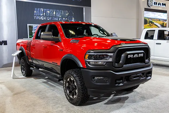 A shiny red 2019 Dodge Ram on display in a car show