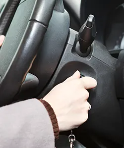 A female driver checking on a car's ignition switch