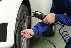 A car mechanic checking a tire's air pressure