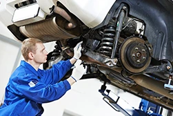 A mechanic examining a car's suspension