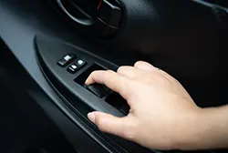 A car mechanic checking on a car's power window switch