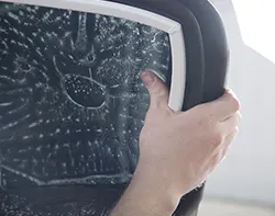 An automobile expert applying car window tint